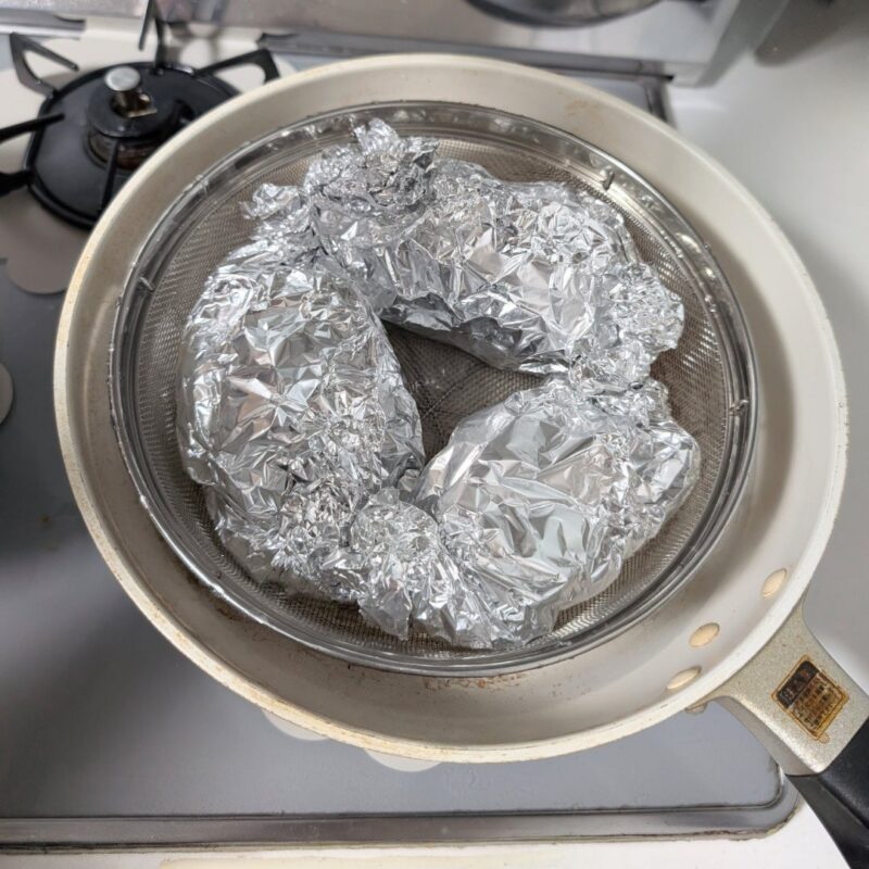 アルミホイルに包んだ魚を蒸し器で調理